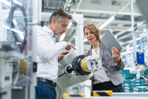 M&D - Businesswoman and man talking at assembly robot in a factory