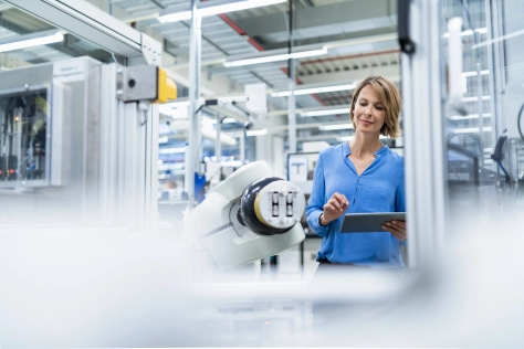 Tech - woman with tablet in a robotics factory 