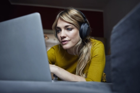 Woman looking at computer with headset on