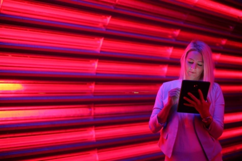 Women with ipad in front of pink screen 
