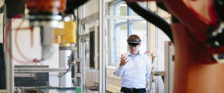 Digital - man with virtual reality glasses in manufacturing warehouse - 1200x500