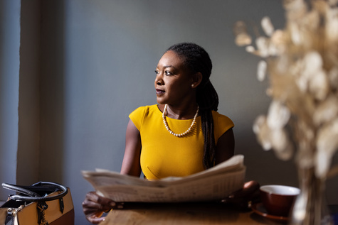 People-women with newspaper at table looking away